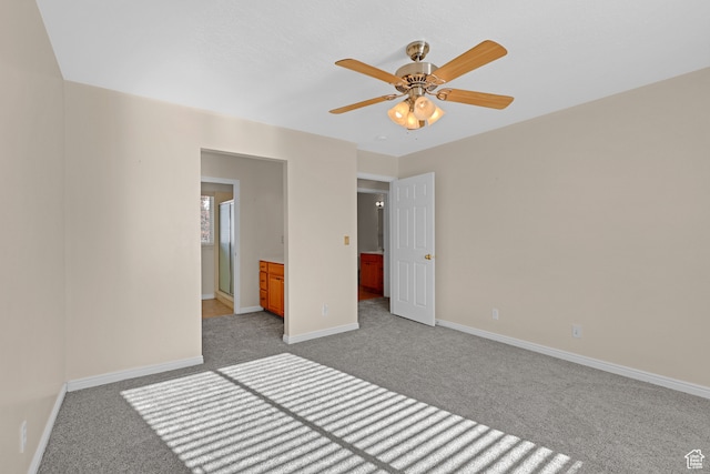 unfurnished bedroom with light carpet, ensuite bathroom, and ceiling fan
