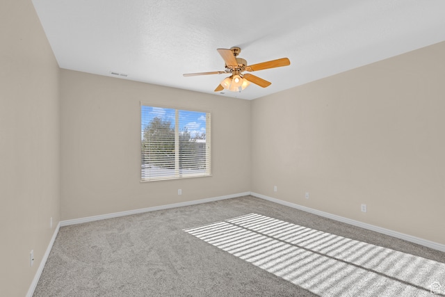 carpeted spare room with ceiling fan