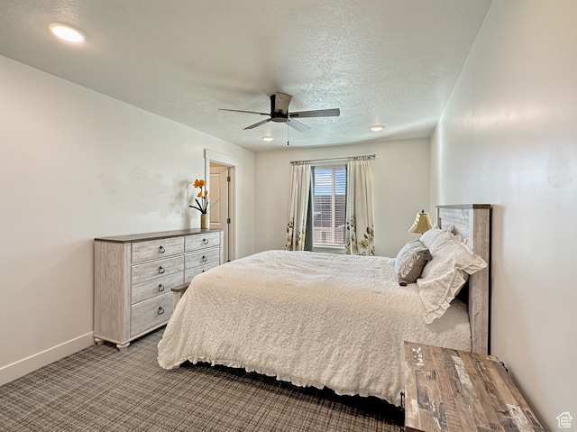 carpeted bedroom with ceiling fan and a textured ceiling