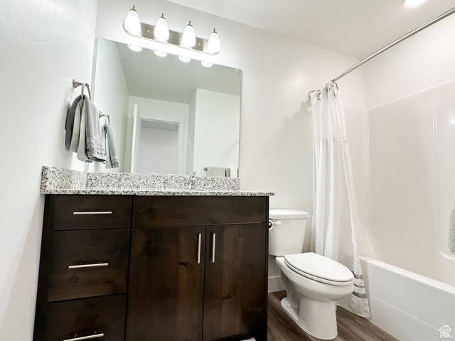 full bathroom featuring vanity, toilet, shower / bathtub combination with curtain, and hardwood / wood-style flooring