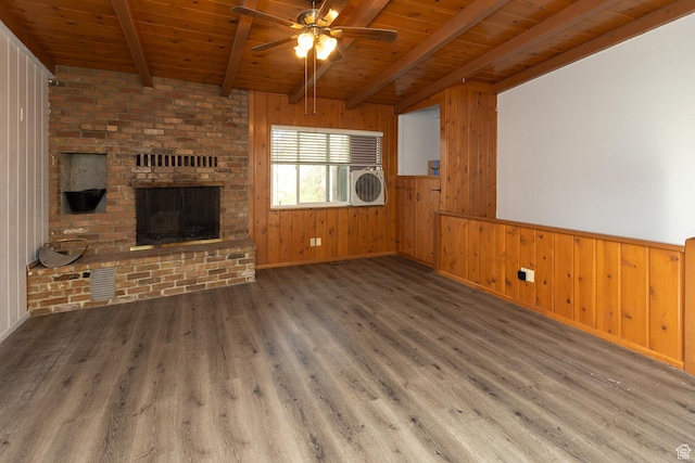 215 N 300 W, Salina, UT 84654 - unfurnished living room with a wood ceiling with exposed beams, a ceiling fan, wooden walls, wood finished floors, and a fireplace