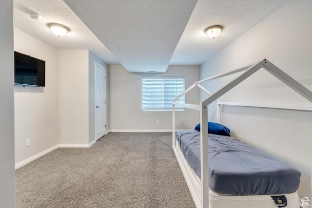 carpeted bedroom featuring a textured ceiling