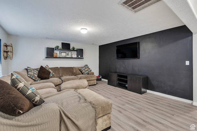 living room with a textured ceiling and light hardwood / wood-style floors