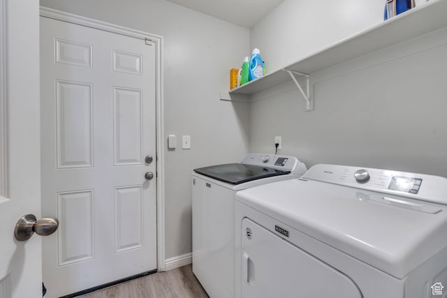 washroom with light wood-type flooring and washing machine and clothes dryer