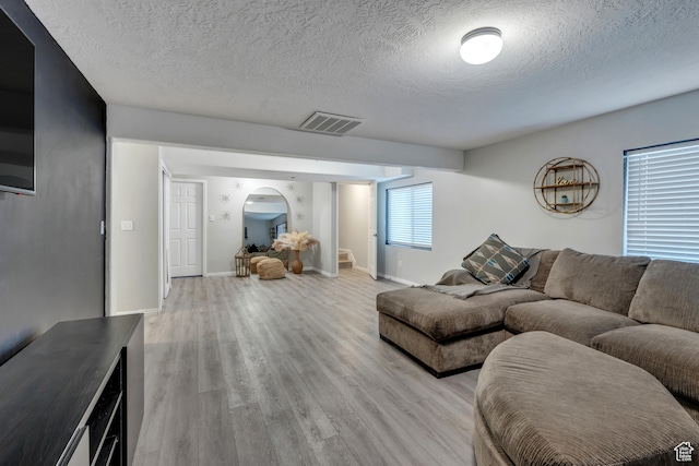 living room featuring light hardwood / wood-style floors and a textured ceiling