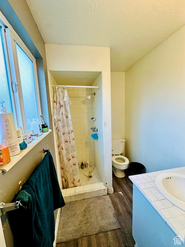 6301 S 2700 W, Taylorsville, UT 84129 - full bathroom with wood finished floors, toilet, a stall shower, vanity, and a textured ceiling