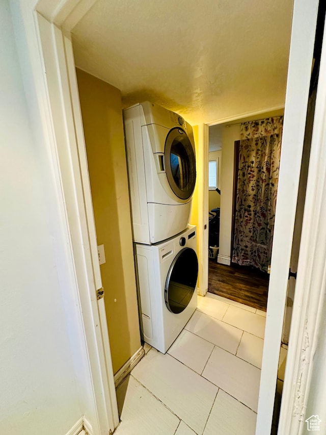 6301 S 2700 W, Taylorsville, UT 84129 - washroom featuring stacked washer / dryer, light tile patterned floors, and baseboards