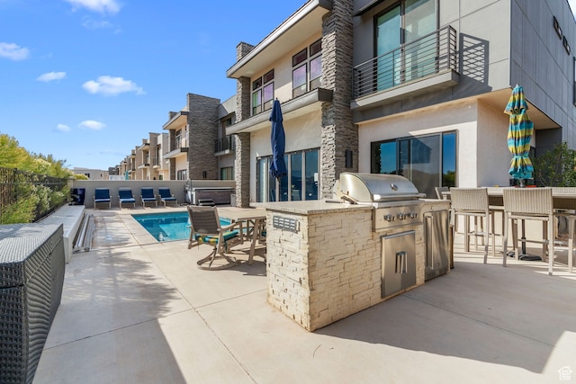 view of swimming pool with a bar, area for grilling, a patio area, and exterior kitchen
