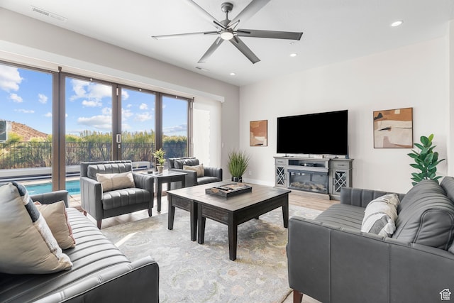 living room with light hardwood / wood-style floors and ceiling fan