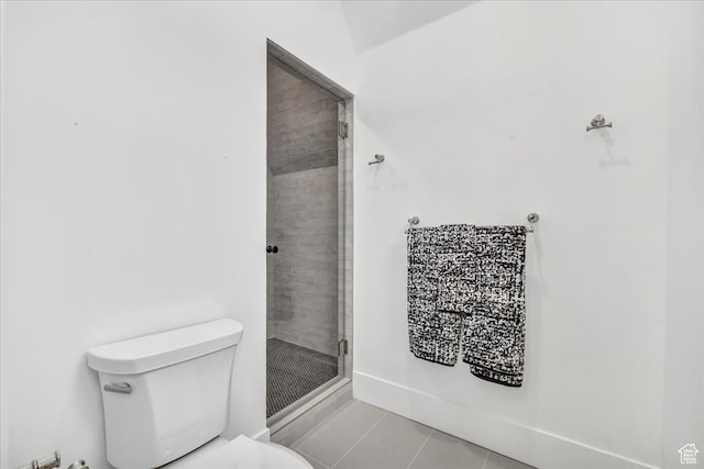 bathroom featuring tile patterned floors, toilet, a shower with door, and vaulted ceiling