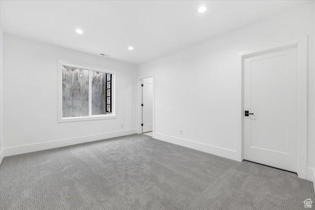 spare room featuring light carpet
