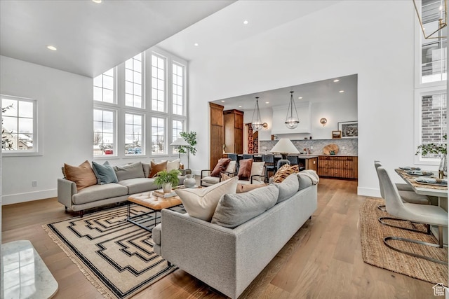 living room with a towering ceiling and light hardwood / wood-style floors