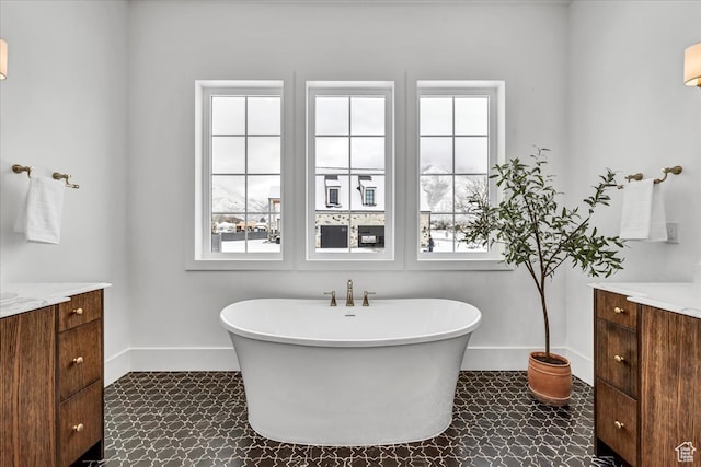 bathroom with vanity, a healthy amount of sunlight, and a tub