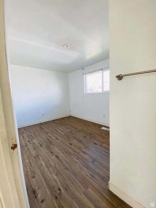 spare room featuring dark wood-type flooring