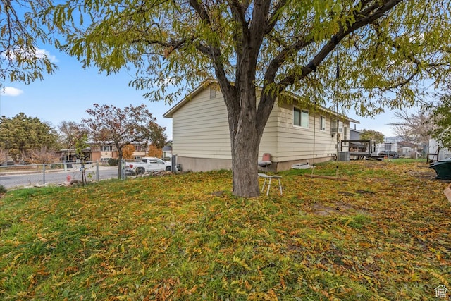view of home's exterior featuring a lawn, cooling unit, and a deck