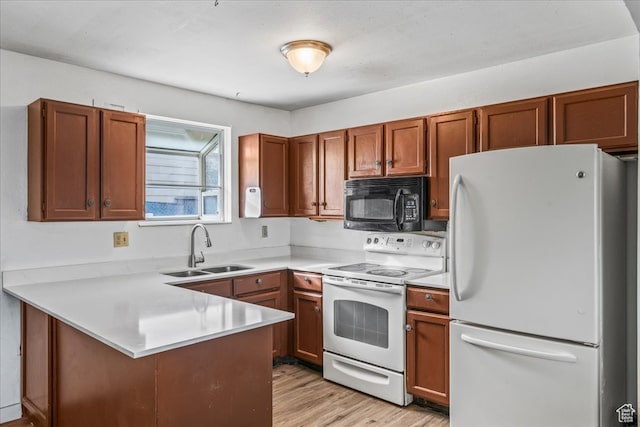 kitchen with kitchen peninsula, sink, white appliances, and light hardwood / wood-style flooring