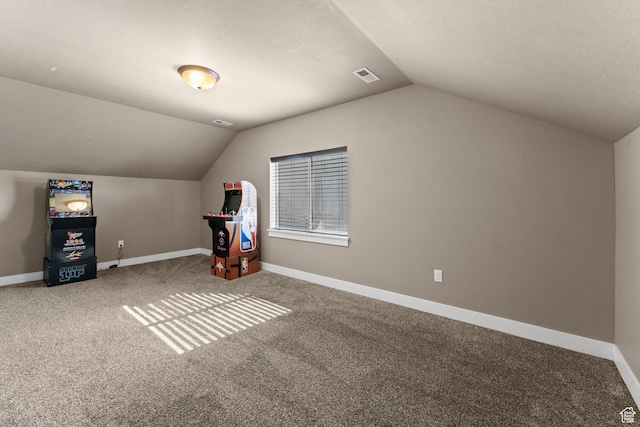 additional living space featuring carpet flooring, a textured ceiling, and lofted ceiling