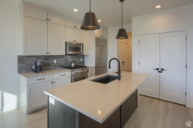 11687 N Shoreline Dr, Hideout, UT 84036 - kitchen featuring tasteful backsplash, a kitchen island with sink, sink, and premium appliances
