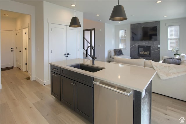 11687 N Shoreline Dr, Hideout, UT 84036 - kitchen featuring a center island with sink, dishwasher, light hardwood / wood-style floors, and decorative light fixtures