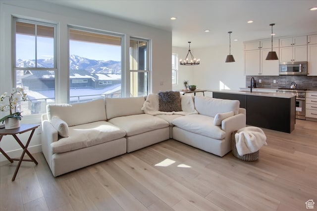 11687 N Shoreline Dr, Hideout, UT 84036 - living room featuring a mountain view, light wood-type flooring, sink, and a chandelier