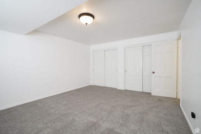 unfurnished bedroom with carpet and two closets