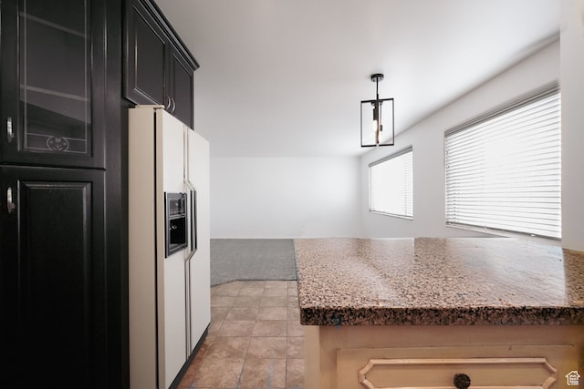 kitchen with decorative light fixtures, light colored carpet, and white refrigerator with ice dispenser