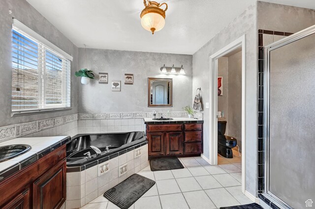 10877 N Wallace Ln E, Tremonton, UT 84337 - full bathroom featuring vanity, tile patterned floors, a shower stall, and a garden tub