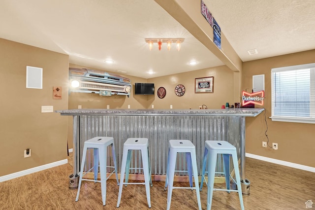 10877 N Wallace Ln E, Tremonton, UT 84337 - kitchen with wood finished floors, baseboards, and a breakfast bar