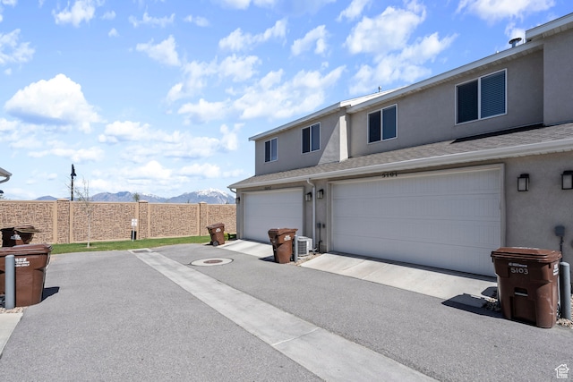 view of front of home with a mountain view, central AC, and a garage