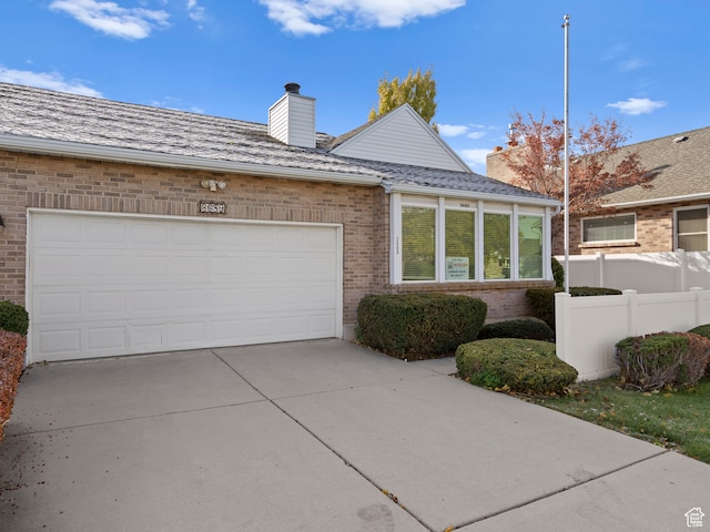 3689 W 5215 S, Taylorsville, UT 84129 - view of front facade with fence, driveway, brick siding, a garage, and a chimney