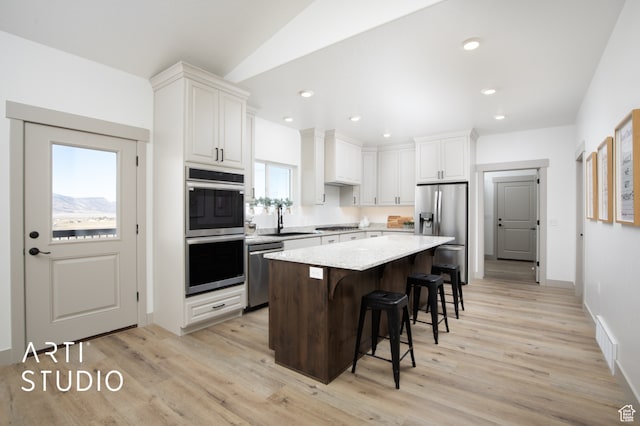 1242 S 500 W Unit 07, Manti, UT 84642 - kitchen featuring a kitchen island, a kitchen breakfast bar, white cabinets, and appliances with stainless steel finishes