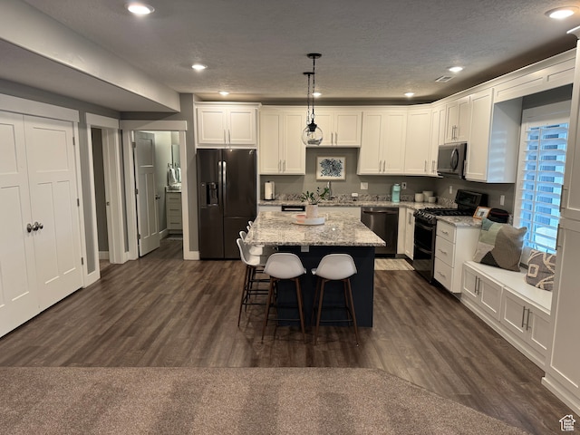 106 E 710 N, Lindon, UT 84042 - kitchen featuring a textured ceiling, dark wood-type flooring, black appliances, decorative light fixtures, and a center island