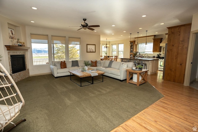 2195 S 1600 W, Richfield, UT 84701 - living area featuring a tiled fireplace, a ceiling fan, wood finished floors, recessed lighting, and a chandelier