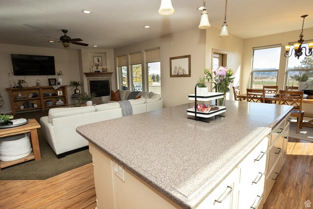 2195 S 1600 W, Richfield, UT 84701 - kitchen featuring a ceiling fan, wood finished floors, a chandelier, decorative light fixtures, and a kitchen island