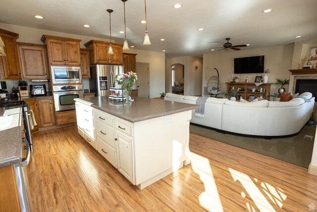 2195 S 1600 W, Richfield, UT 84701 - kitchen featuring appliances with stainless steel finishes, ceiling fan, a center island, light hardwood / wood-style floors, and hanging light fixtures