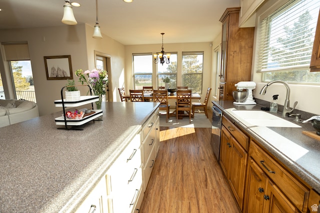 2195 S 1600 W, Richfield, UT 84701 - kitchen featuring stainless steel dishwasher, sink, wood-type flooring, white cabinets, and a chandelier