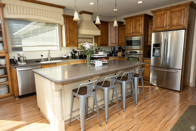 2195 S 1600 W, Richfield, UT 84701 - kitchen with appliances with stainless steel finishes, light wood-type flooring, a kitchen island, hanging light fixtures, and a breakfast bar area