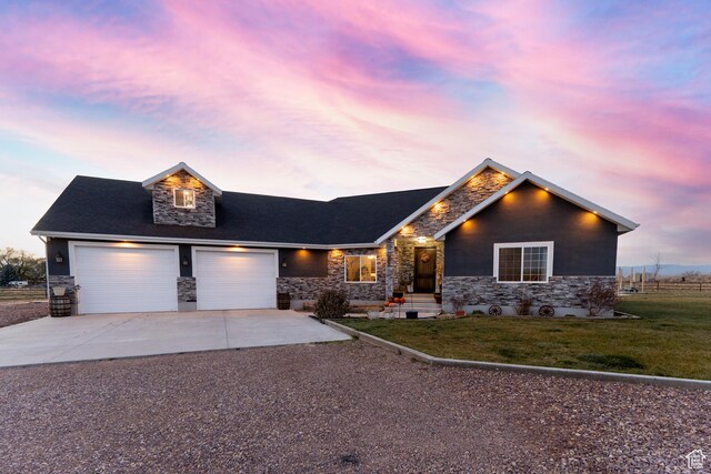 5361 N 4500 E, Roosevelt, UT 84066 - view of front of house featuring stone siding, driveway, a yard, and a garage