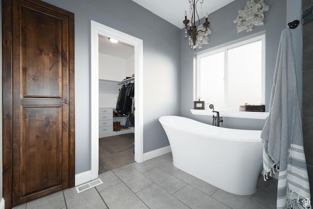 5361 N 4500 E, Roosevelt, UT 84066 - full bathroom featuring a freestanding tub, a walk in closet, baseboards, tile patterned floors, and a chandelier