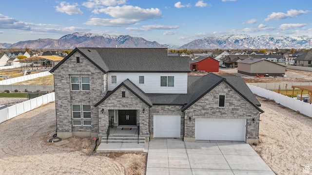 2118 N Snowy Crane Dr, Clinton, UT 84015 - view of front facade with a mountain view, concrete driveway, roof with shingles, stone siding, and an attached garage