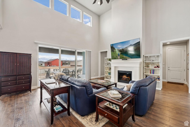 2118 N Snowy Crane Dr, Clinton, UT 84015 - living room with a high ceiling, a glass covered fireplace, wood-type flooring, baseboards, and ceiling fan