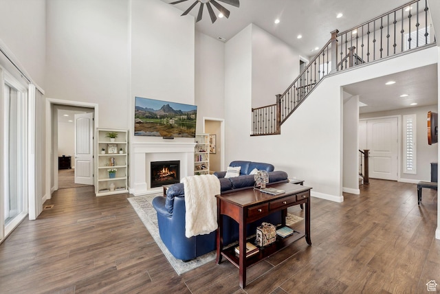 2118 N Snowy Crane Dr, Clinton, UT 84015 - living area with a towering ceiling, wood finished floors, baseboards, a glass covered fireplace, and a ceiling fan