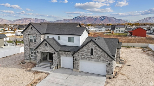 2118 N Snowy Crane Dr, Clinton, UT 84015 - french provincial home featuring a mountain view, stone siding, driveway, and a shingled roof