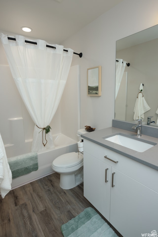 full bathroom featuring shower / bath combo with shower curtain, vanity, wood-type flooring, and toilet