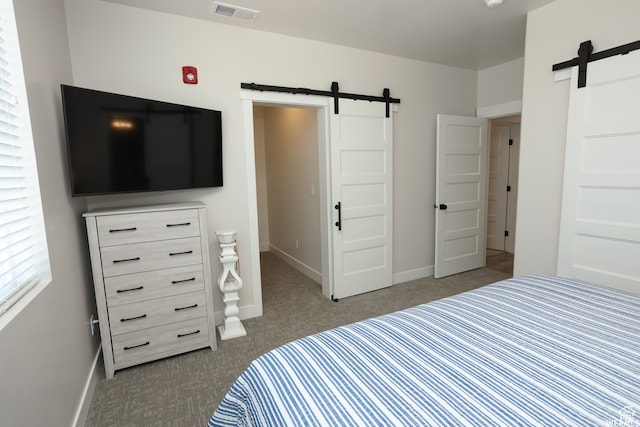 carpeted bedroom featuring a barn door