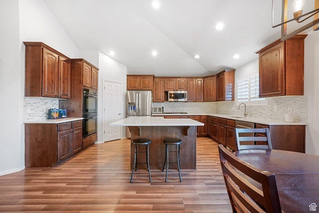 758 W Cedar View Dr, Saratoga Springs, UT 84045 - kitchen featuring vaulted ceiling, a kitchen bar, appliances with stainless steel finishes, a center island, and light countertops