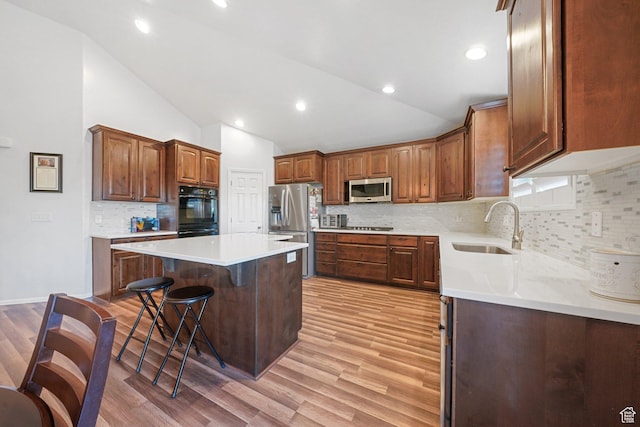 758 W Cedar View Dr, Saratoga Springs, UT 84045 - kitchen with stainless steel appliances, vaulted ceiling, a kitchen breakfast bar, light wood finished floors, and a center island