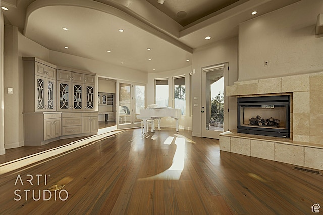 unfurnished living room with a tile fireplace and dark hardwood / wood-style floors