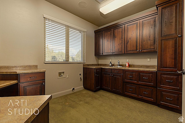kitchen featuring light colored carpet, sink, and dark brown cabinets