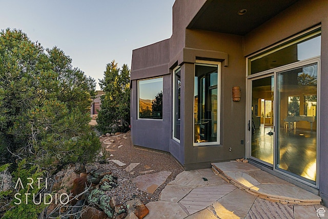 exterior entry at dusk with a patio area